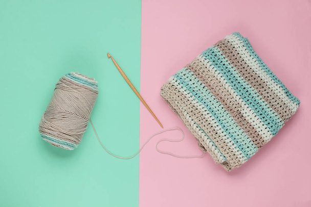 Yarn with skeins of woolen threads and a wooden crochet for knitting on a blue-pink pastel background. Top view - Photo, image