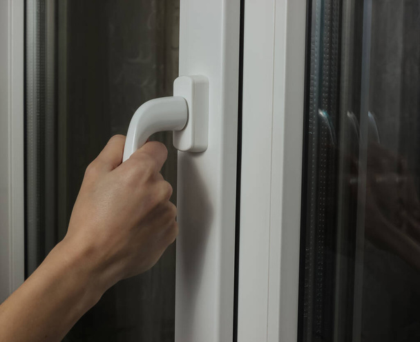 Female hand opens a metal-plastic window for ventilation - Photo, Image