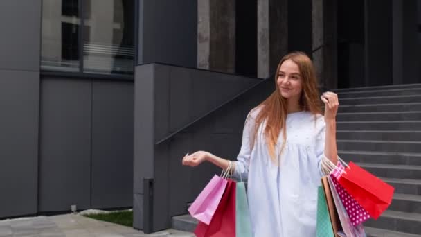Menina andando do shopping com sacos de compras. Conceito de descontos de venda, preços baixos na Black Friday - Filmagem, Vídeo