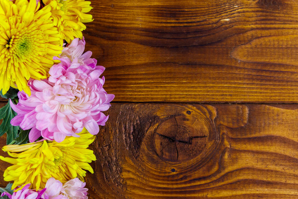 Beautiful chrysanthemums on wooden background. Top view, copy space - Fotó, kép