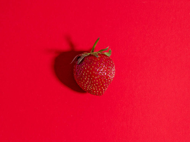 Delicious natural strawberries on a bright red background. healthy food, top view - Photo, image