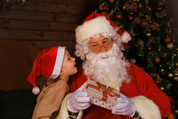 Santa Claus and child at home. Christmas gift. Family holiday concept - Foto, afbeelding