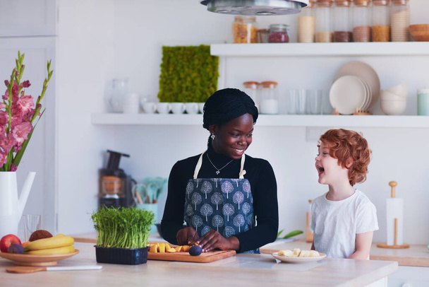 cheerful multiracial family, mother and son having fun on the kitchen - Photo, Image