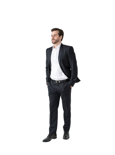 Isolated full length portrait of young businessman standing with hands in pockets. Concept of management - Фото, изображение