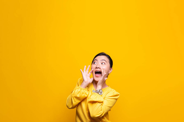 felice donna fare grido gesto isolato su sfondo giallo - Foto, immagini