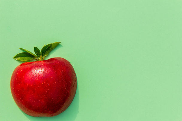 Tuore maukas punainen omena vihreällä taustalla, hyvä vegaaniruoka, aakkoset ja mainos, vitamiinit immuunijärjestelmään - Valokuva, kuva