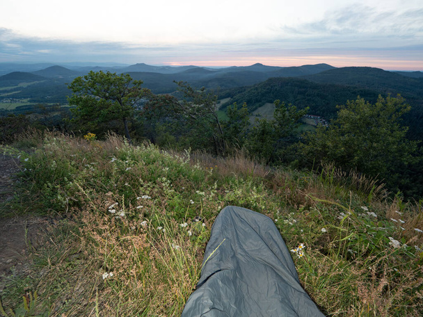 Réveillez-vous tôt le matin auberge sac de couchage sur le sommet de la montagne. Dormir dans la nature dans un sac de couchage. Bel éveil dans les rochers.  - Photo, image