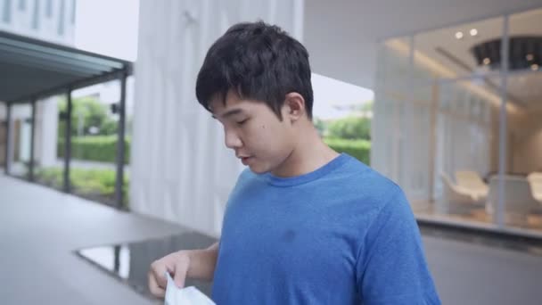 Nuori aasialainen mies yllään lääketieteellinen naamio - Materiaali, video