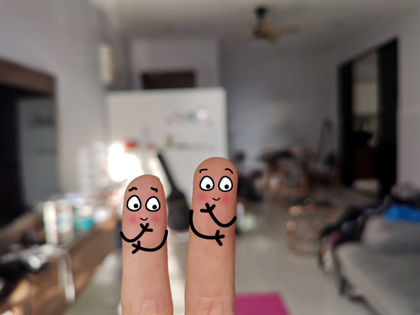 Dos dedos están decorados como dos personas. Están en una casa desordenada.. - Foto, imagen