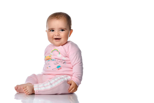 Cute little girl laughs looking at the camera on a white background. - Фото, изображение