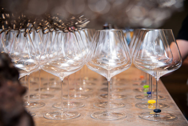 鮮やかな花の装飾テーブルに設置された抽象的な空のワイングラス - 写真・画像