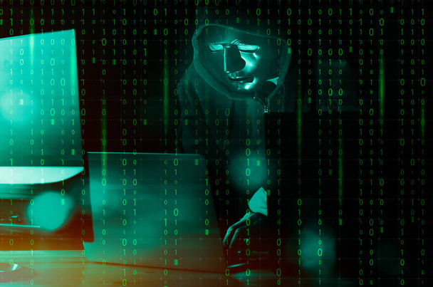 Hacker und Malware-Konzept. Gefährlicher Hacker mit Kapuze nutzt Laptop mit digitaler Binärcode-Schnittstelle. - Foto, Bild