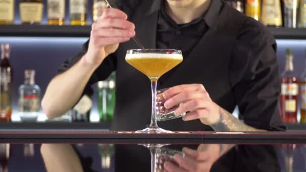 Barista che prepara cocktail alcolici freschi sul bancone del bar - Filmati, video