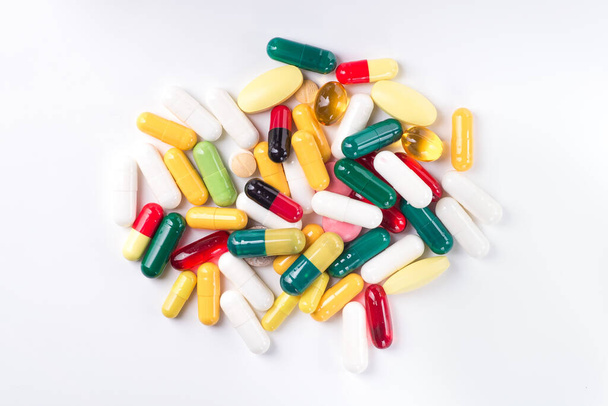 Pile de pilules colorées isolées sur un fond blanc. différentes options de traitement. - Photo, image