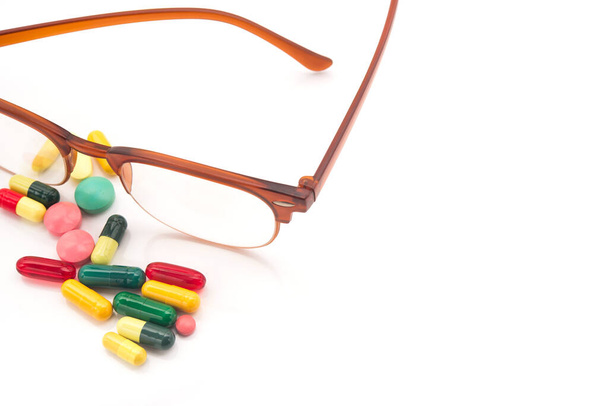 Visión gafas y pastillas vitaminas para mejorar los ojos. Aislado sobre un fondo blanco. - Foto, imagen