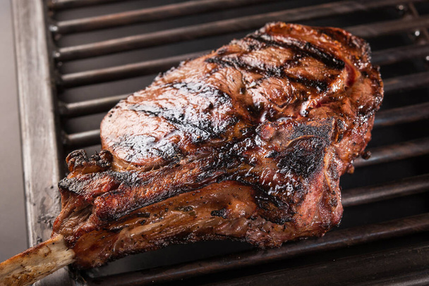 Gros plan de steak de viande grillée sur un gril métallique - Photo, image