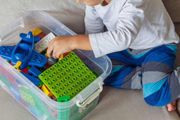 Child playing with toy blocks sitting on the sofa - Foto, Imagem