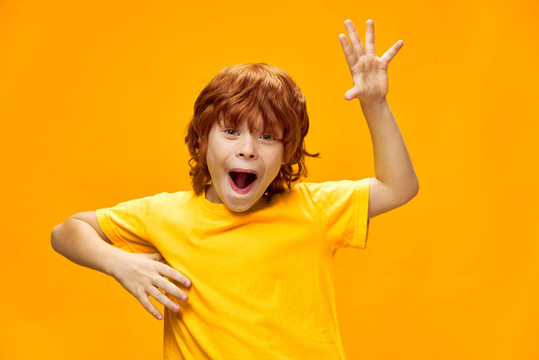 Wyraźny chłopiec z rudymi włosami zabawny wyraz twarzy gestykulujący rękami Kopiuj przestrzeń - Zdjęcie, obraz
