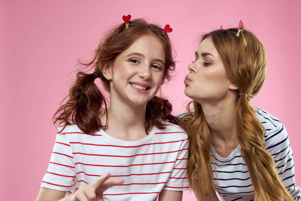 Fröhlich Mutter und Tochter Lebensstil Freude gestreifte Hemden Familie rosa Hintergrund - Foto, Bild