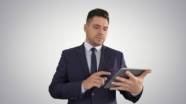 Businessman presenting from the tablet on gradient background. - Foto, imagen