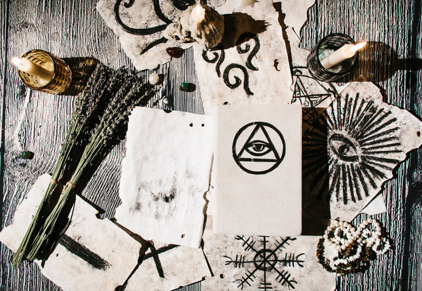 Livre magique blanc posé sur la table avec de vieux manuscrits avec des symboles occultes, des bougies, de la lavande. Concept de la bonne aventure, rituel, autel, spiritisme, connaissance secrète - Photo, image