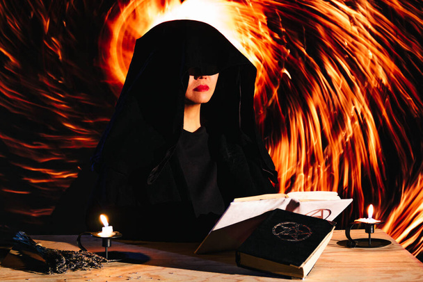 Boszorkány okkult rituálét folytat, spirituális dimenziós portált nyit, fekete-fehér mágikus szimbólumokkal az oltáron. - Fotó, kép