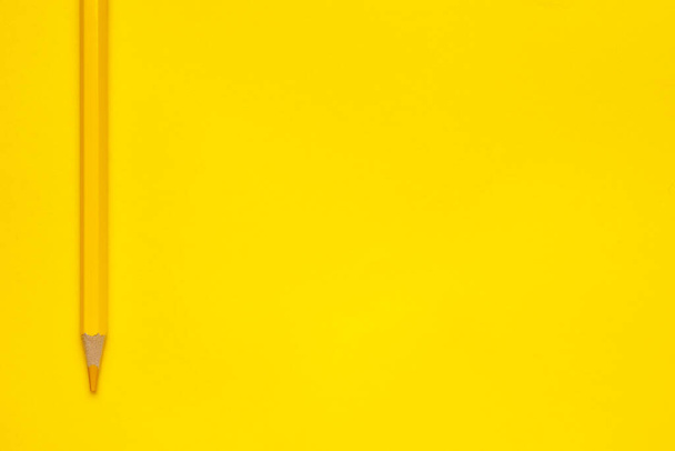 vertical yellow sharp wooden pencil on a bright yellow background, isolated, copy space, mock up - Zdjęcie, obraz