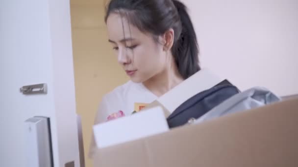 Karton kutu taşıyan genç Asyalı kadın yeni daireye giriyor, kahverengi karton kutu konteynır, ev kredisi, yeni odaya taşınma, depo teslimatı, bekar kadın. - Video, Çekim
