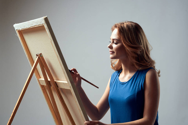 Woman artist with brush paint on easel art hobby light background - Photo, image