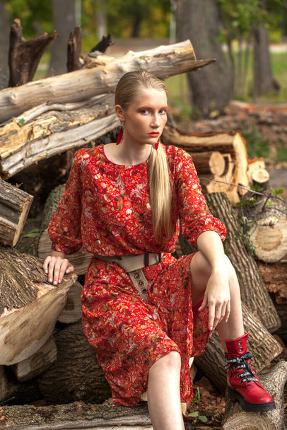 Portrait of a stylish model in long red flowers dress  - Фото, изображение