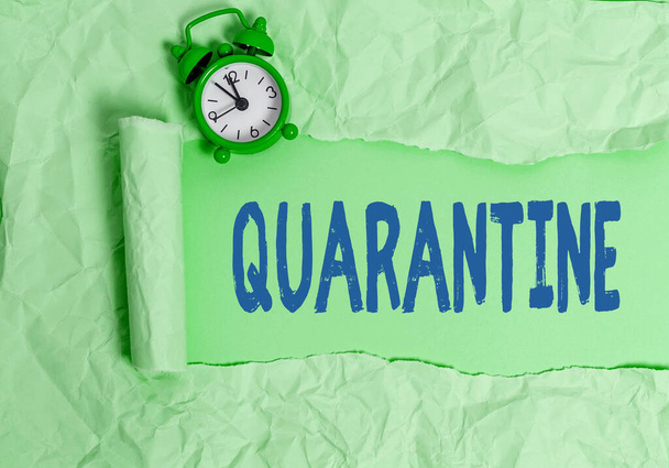 Text sign showing Quarantine. Conceptual photo restraint upon the activities of an individual or the transport of goods Rolled ripped torn cardboard placed above a wooden classic table backdrop. - Photo, Image