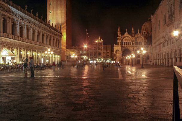 Geceleri Venezia, İtalya 'da, Piazza San Marco' da. Geceleri, oradan geçen turistlerin belirsizliğiyle. Saint Marks Meydanı olarak da bilinir, Piazza San Marco Venedik 'teki en ikonik yerdir. - Fotoğraf, Görsel