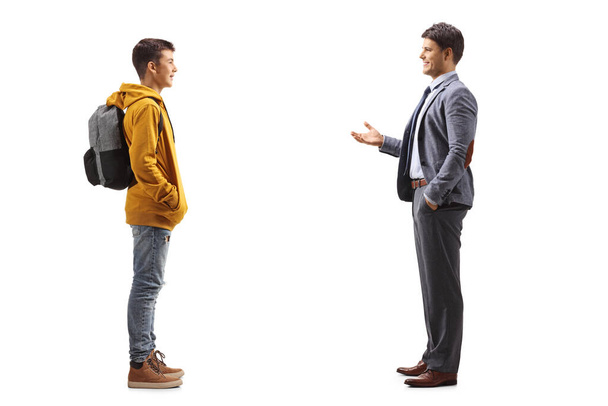 Full length profile shot of a male teenager listening to his father talking isolated on white background - Foto, afbeelding