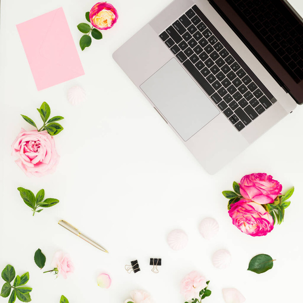 Laptop com flores de rosas e espaço de cópia no fundo branco. Deitado. Vista superior. - Foto, Imagem