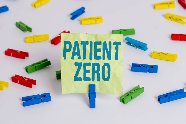 Writing note showing Patient Zero. Business photo showcasing primary disease carrier of the highlycontagious disease Colored clothespin papers empty reminder white floor background office. - Photo, Image