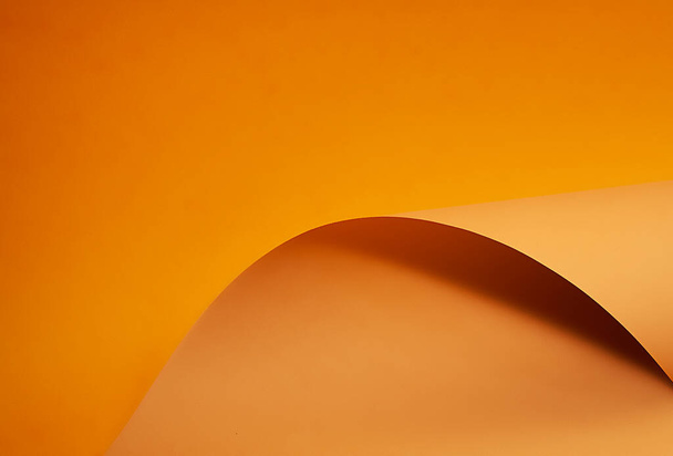 Oranssi ja ruskea paperi on kaareva aaltoileva viiva, kaunis pehmeä valo ja varjo paperilla, abstrakti tausta suunnittelijoille. - Valokuva, kuva