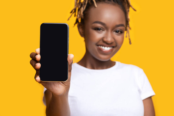 Wesoły czarny kobieta pokazuje smartfon z pusty ekran - Zdjęcie, obraz