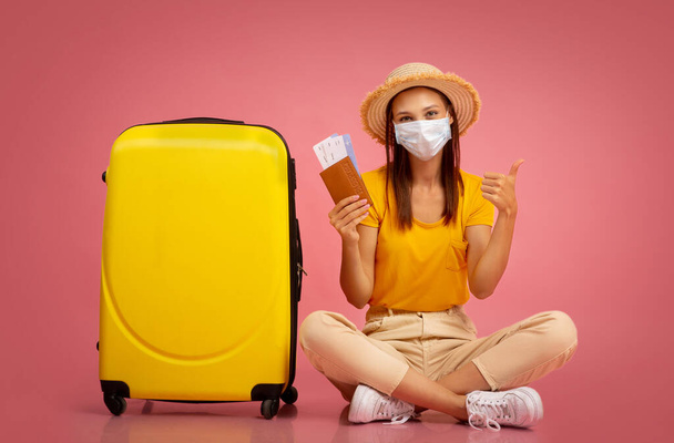 Femme heureuse avec passeport et billets assis à côté des bagages - Photo, image
