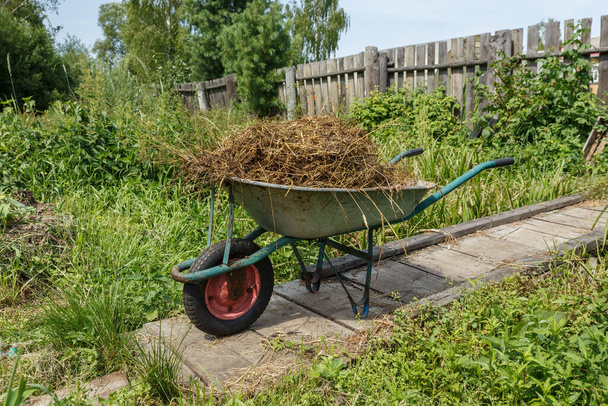 garden cart with natural cow dung. The cart is on a wooden bridge near the fence. - Photo, Image