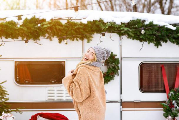 Zimowa radość. Piękna blondynka pozowanie w pobliżu kampingu w drewnie - Zdjęcie, obraz