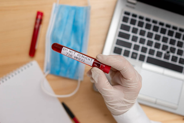 Handwriting text writing Do Not Reinvent The Wheel. Concept meaning stop duplicating a basic method previously done Extracted blood sample vial with lastest technology ready for examination. - Photo, Image