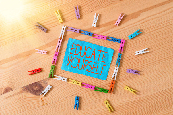 Conceptual hand writing showing Educate Yourself. Business photo text prepare oneself or someone in a particular area or subject Colored crumpled papers wooden floor background clothespin. - Photo, Image