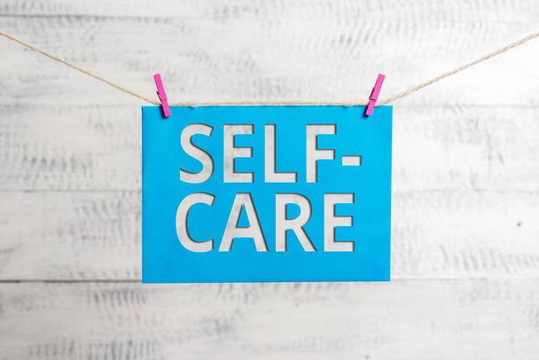 Kézírás szöveg Self Care. Koncepció jelentése a gyakorlat, hogy tegyen lépéseket, hogy javítsa az egyik s a saját egészség Ruhaszárító téglalap alakú papír emlékeztető fehér fa íróasztal. - Fotó, kép