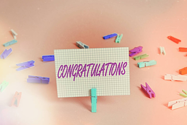 Writing note showing Congratulations. Business photo showcasing a congratulatory expression usually used in plural form Colored crumpled rectangle shaped reminder paper light blue background. - Photo, Image