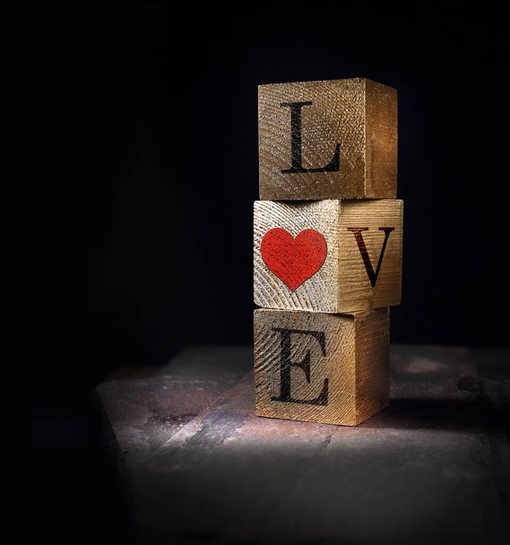 Quadri cubo impilati creativamente illuminati di vero legno con messaggio d'amore di San Valentino, concept image. Sistemazione generosa per spazio copia. - Foto, immagini