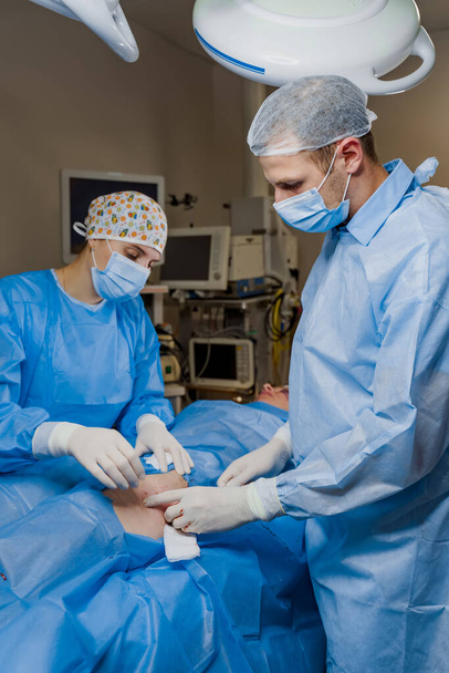 Liposuction for lipofilling surgery operation. 2 surgeon do plastic surgery named blepharoplasty in medical clinic. - Φωτογραφία, εικόνα