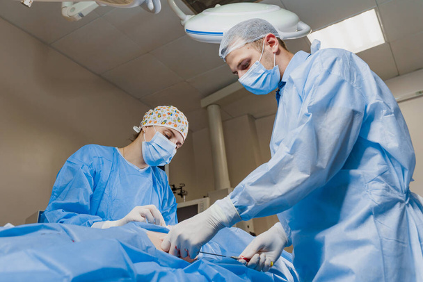 Liposuctie voor lipofilling operatie. 2 chirurg doen plastische chirurgie genaamd blefaroplastiek in de medische kliniek. - Foto, afbeelding
