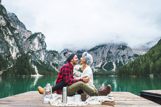 Beautiful couple of young adults visiting an alpine lake at Braies, Italy - Tourists with hiking outfit having fun on vacation during autumn foliage - Concepts about travel, lifestyle and wanderlust - Foto, immagini