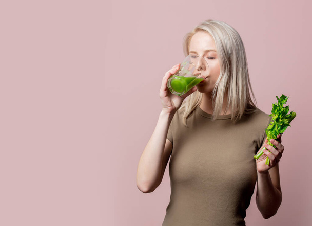 Blonde girl with celery juice on pink background  - Photo, Image