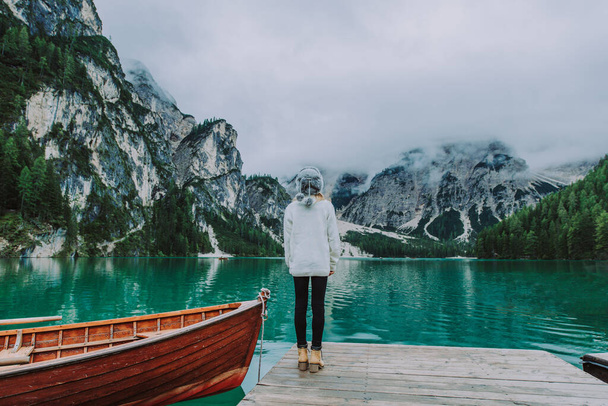 Beautiful woman visiting an alpine lake at Braies, Italy - Tourist with hiking outfit having fun on vacation during autumn foliage - Concepts about travel, lifestyle and wanderlust - Φωτογραφία, εικόνα